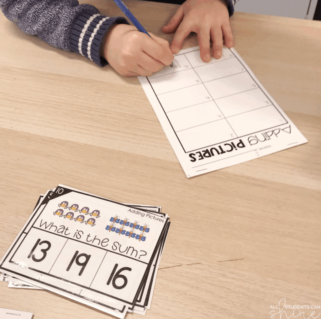 Student working on an “Adding Pictures” math task card activity, writing answers on a recording sheet. Hands-on math practice like this is a great option for early finishers in the classroom.