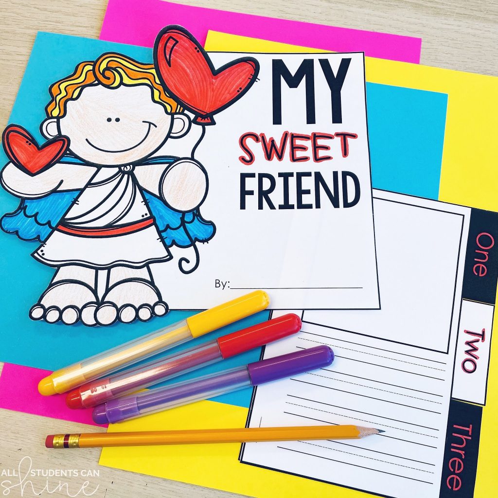 A hands-on free friendship activity combining a craft and writing project. The design features a cartoon-style Cupid holding heart balloons, with a student-created booklet titled "My Sweet Friend." The writing prompts encourage kids to describe a friend in three ways. The materials, including colorful pens and a pencil, are displayed on bright construction paper for an inviting and creative learning experience.