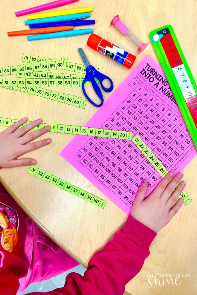 Student cutting and organizing number strips to practice sequencing for number sense